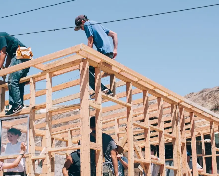 A Local Buyer-Home-Framing-Construction Construction crew framing the wooden roof structure of a new residential project by A Local Buyer.